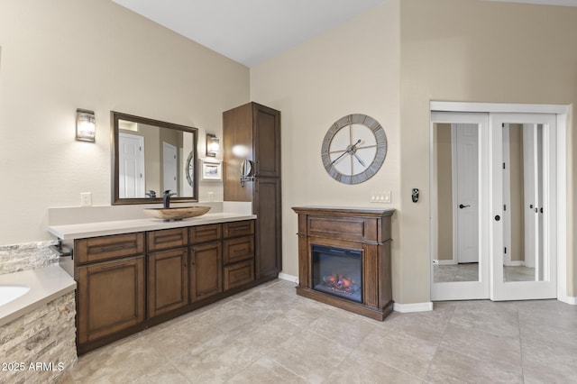 bathroom featuring a tub, french doors, and vanity