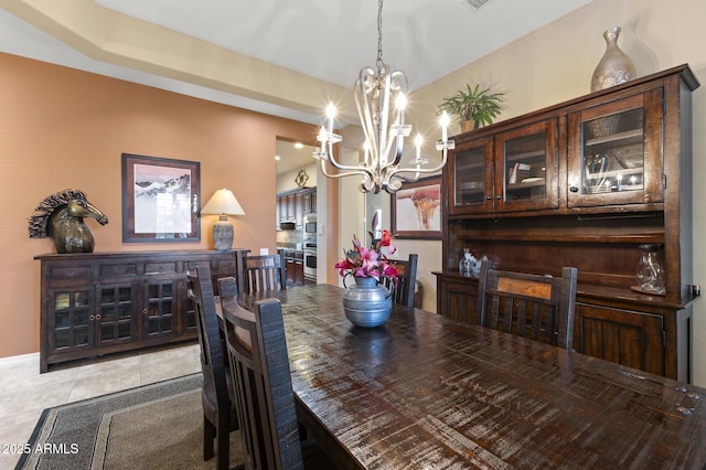 tiled dining space featuring a chandelier