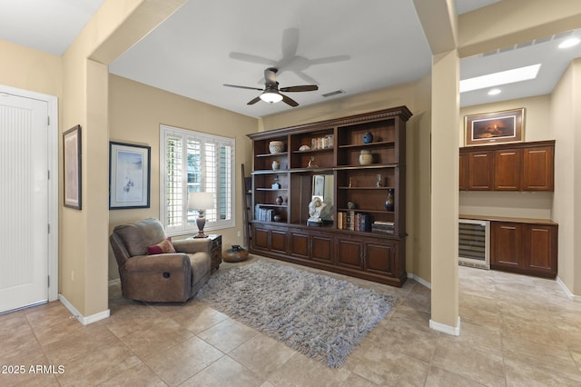 sitting room with ceiling fan and beverage cooler