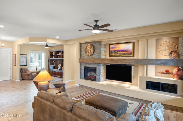 living room featuring a fireplace and ceiling fan