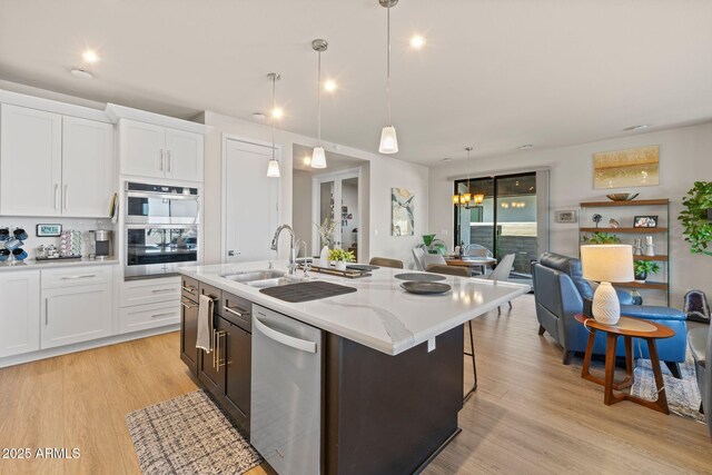 4947 N Mclaury Dr, Prescott Valley, AZ 86314 - kitchen featuring light wood finished floors, white cabinets, a sink, and stainless steel appliances