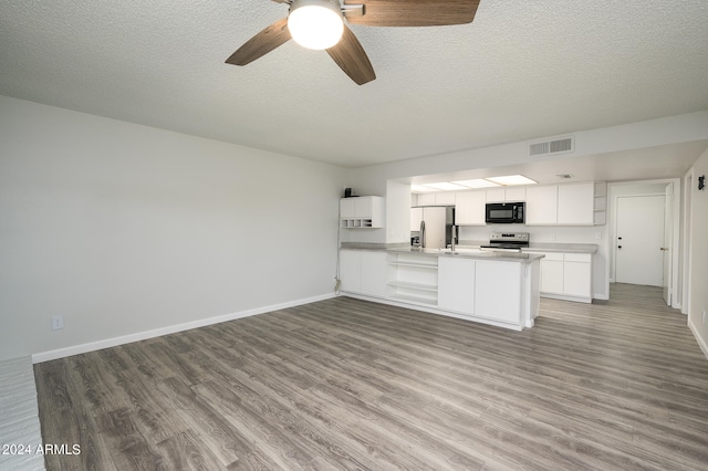 kitchen with appliances with stainless steel finishes, light hardwood / wood-style floors, white cabinetry, kitchen peninsula, and ceiling fan