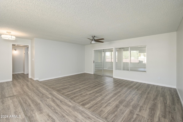 spare room featuring wood-type flooring, ceiling fan, and a textured ceiling