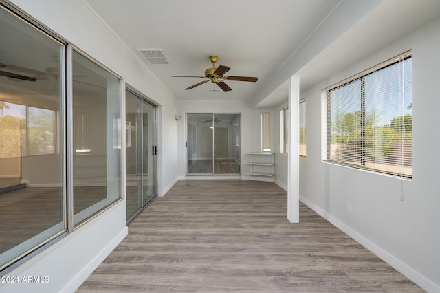 unfurnished sunroom featuring ceiling fan and visible vents