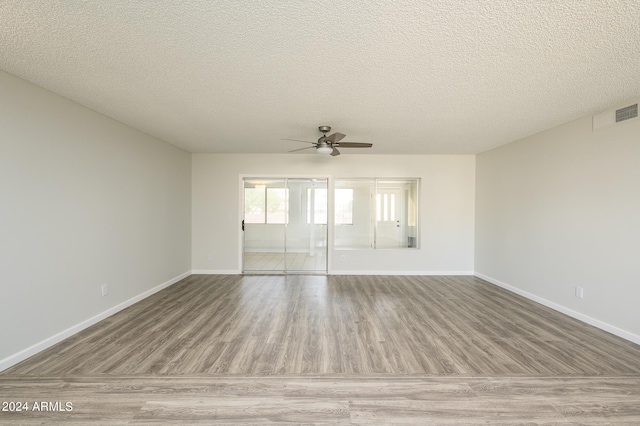 spare room with light wood-type flooring, a textured ceiling, and ceiling fan