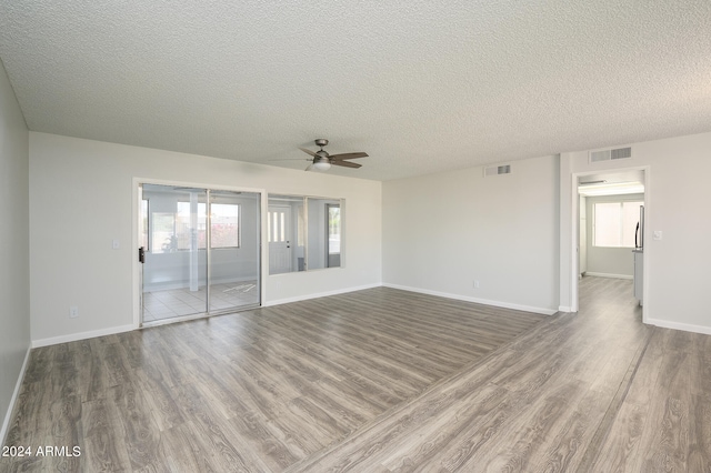 empty room featuring a textured ceiling, ceiling fan, and hardwood / wood-style flooring