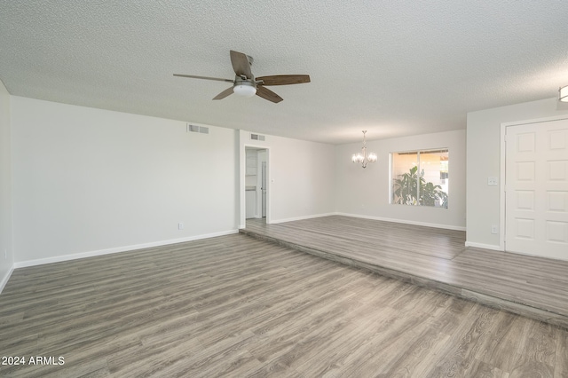 empty room featuring a textured ceiling, ceiling fan with notable chandelier, and hardwood / wood-style flooring