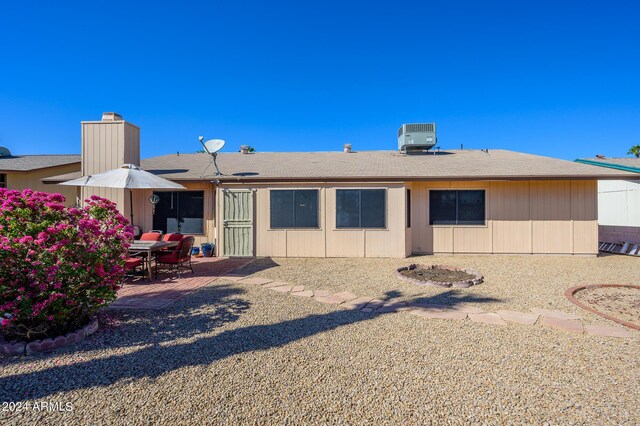 back of property featuring central AC, a patio, and a chimney