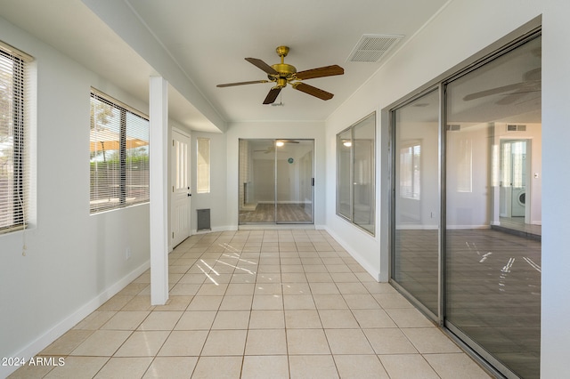 corridor featuring light tile patterned floors and washer / dryer