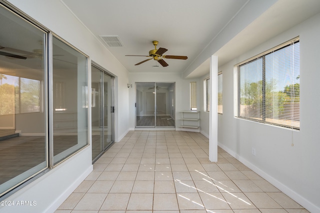 unfurnished sunroom featuring ceiling fan