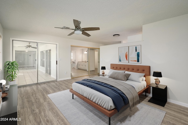 bedroom featuring light wood-type flooring, ensuite bath, ceiling fan, and a textured ceiling