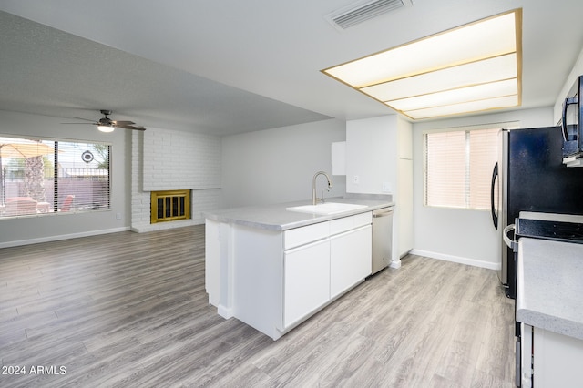 kitchen featuring light wood-type flooring, range, sink, white cabinets, and ceiling fan