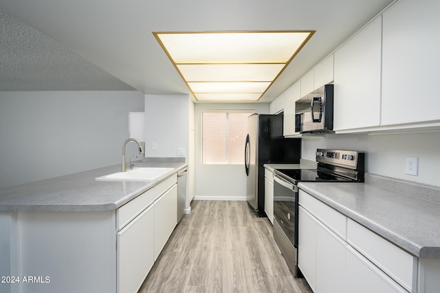 kitchen with white cabinets, sink, appliances with stainless steel finishes, and light hardwood / wood-style floors