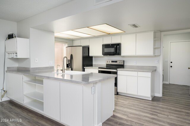 kitchen with open shelves, appliances with stainless steel finishes, visible vents, and light wood-style floors