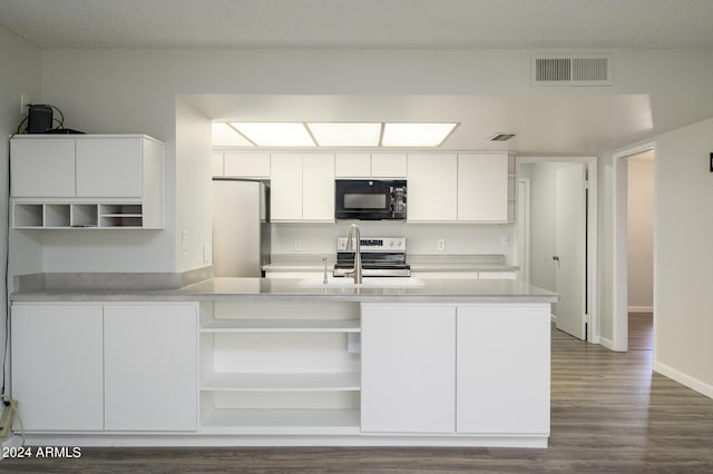 kitchen featuring black microwave, open shelves, and freestanding refrigerator