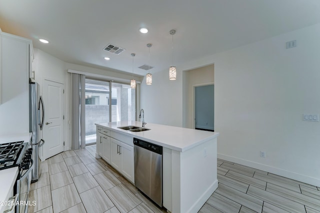 4927 S Tune, Mesa, AZ 85212 - kitchen featuring appliances with stainless steel finishes, white cabinets, an island with sink, light countertops, and hanging light fixtures