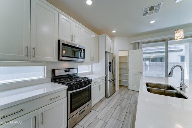 4927 S Tune, Mesa, AZ 85212 - kitchen with stainless steel appliances, white cabinets, decorative light fixtures, recessed lighting, and light stone countertops