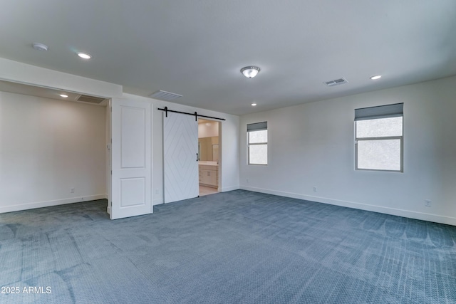 4927 S Tune, Mesa, AZ 85212 - unfurnished bedroom with a barn door, carpet flooring, recessed lighting, and ensuite bathroom