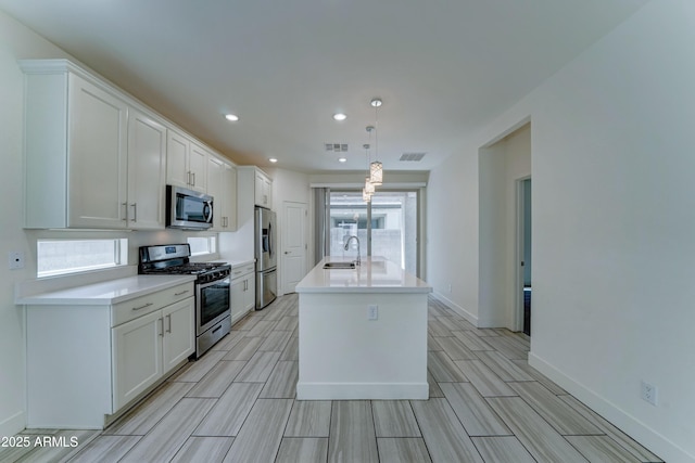 4927 S Tune, Mesa, AZ 85212 - kitchen with appliances with stainless steel finishes, white cabinets, wood finish floors, a kitchen island with sink, and recessed lighting