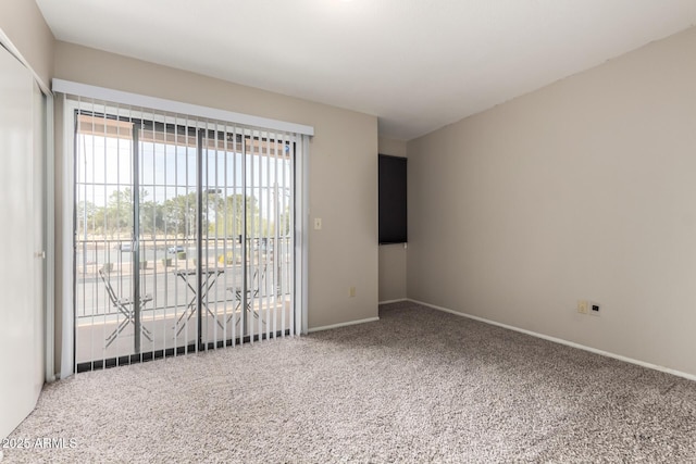 unfurnished room featuring carpet and baseboards