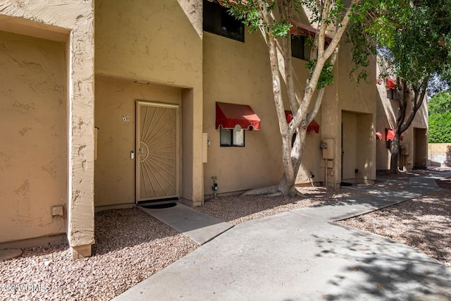 doorway to property featuring stucco siding