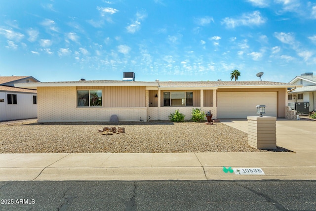 ranch-style home featuring a garage, concrete driveway, and brick siding