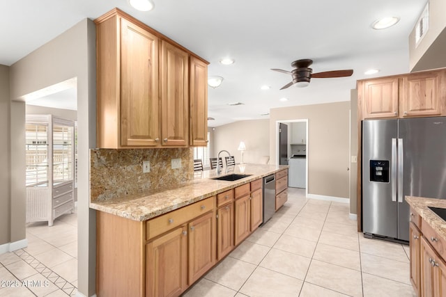 kitchen with ceiling fan, a sink, stainless steel appliances, washer / dryer, and light tile patterned floors