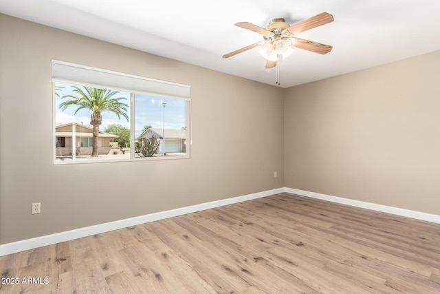 empty room featuring baseboards, ceiling fan, and wood finished floors