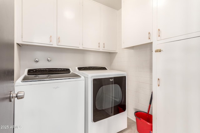 clothes washing area with cabinet space and separate washer and dryer