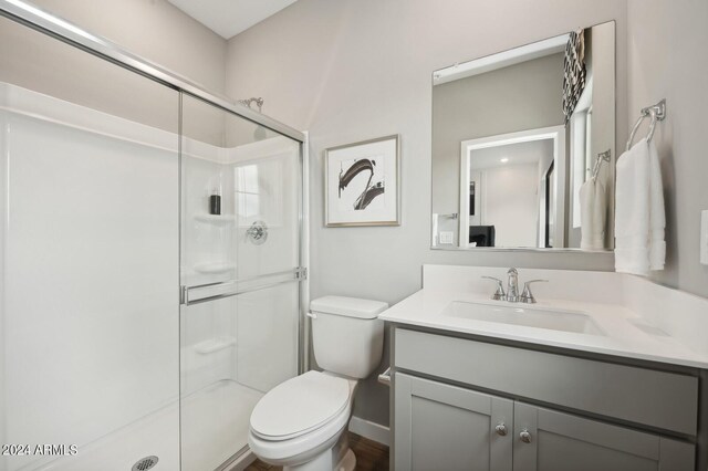 bathroom featuring an enclosed shower, vanity, and toilet