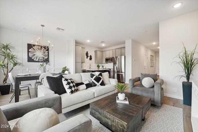 living room featuring an inviting chandelier and light hardwood / wood-style flooring