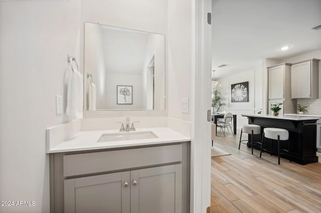 bathroom featuring backsplash, sink, and hardwood / wood-style floors