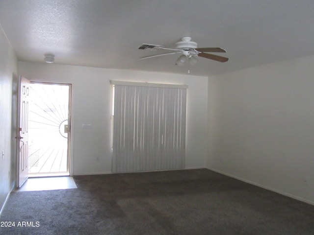 carpeted spare room featuring ceiling fan and a textured ceiling