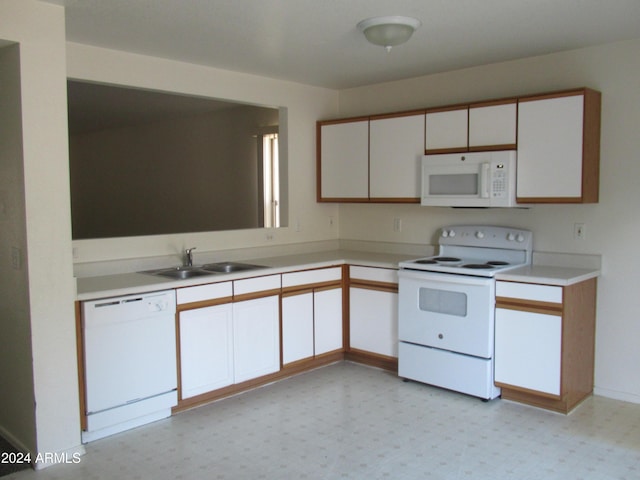 kitchen with white cabinetry, white appliances, and sink