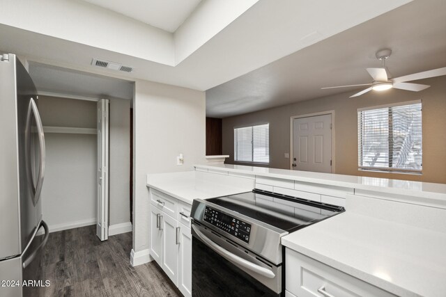 kitchen with kitchen peninsula, white cabinetry, dark hardwood / wood-style flooring, appliances with stainless steel finishes, and ceiling fan