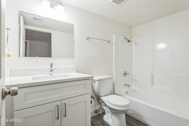 full bathroom featuring a textured ceiling, toilet, vanity, hardwood / wood-style flooring, and shower / bathtub combination