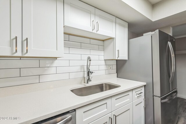 kitchen featuring decorative backsplash, sink, white cabinetry, appliances with stainless steel finishes, and dark hardwood / wood-style flooring