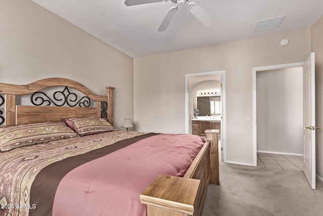 carpeted bedroom featuring a ceiling fan, ensuite bathroom, and baseboards