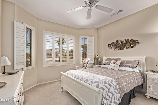 bedroom with ceiling fan, light colored carpet, visible vents, and baseboards