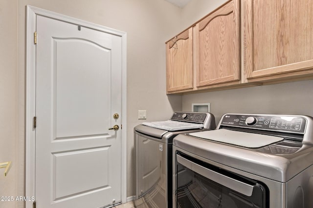 clothes washing area featuring cabinet space and independent washer and dryer