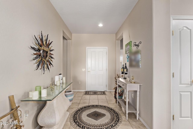 entrance foyer featuring light tile patterned floors and baseboards