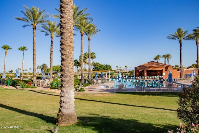 view of community featuring a pool and a lawn