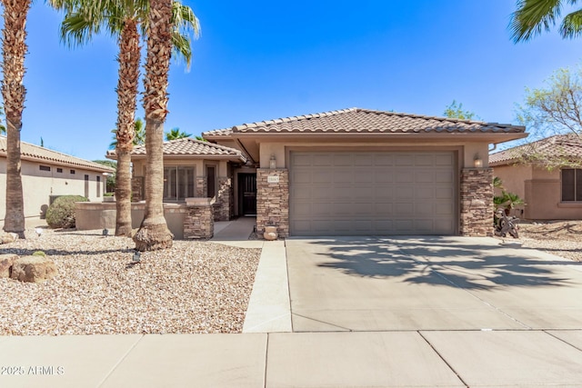 prairie-style home with stucco siding, driveway, a tile roof, stone siding, and an attached garage