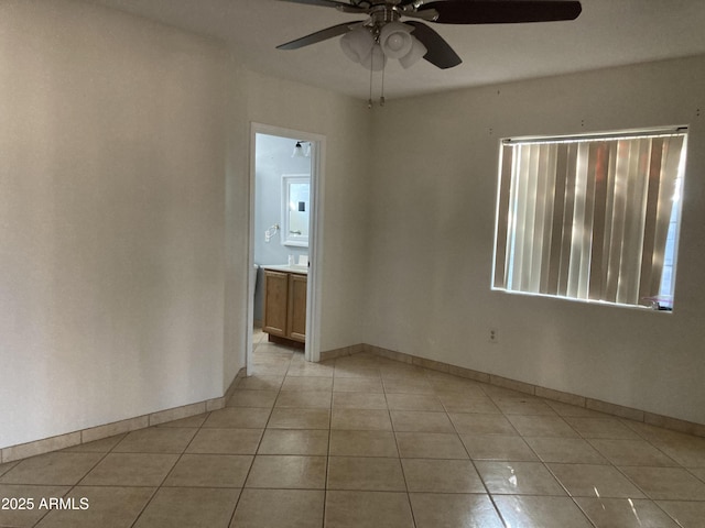 spare room featuring light tile patterned floors and ceiling fan