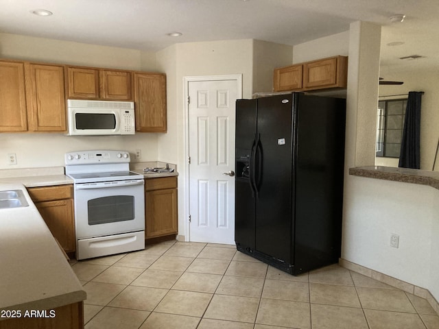 kitchen featuring light tile patterned floors, white appliances, and sink