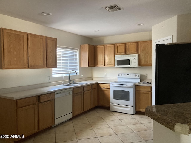 kitchen with light tile patterned flooring, white appliances, and sink