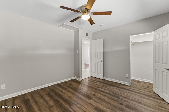 unfurnished bedroom with ceiling fan, dark hardwood / wood-style floors, a closet, and a spacious closet