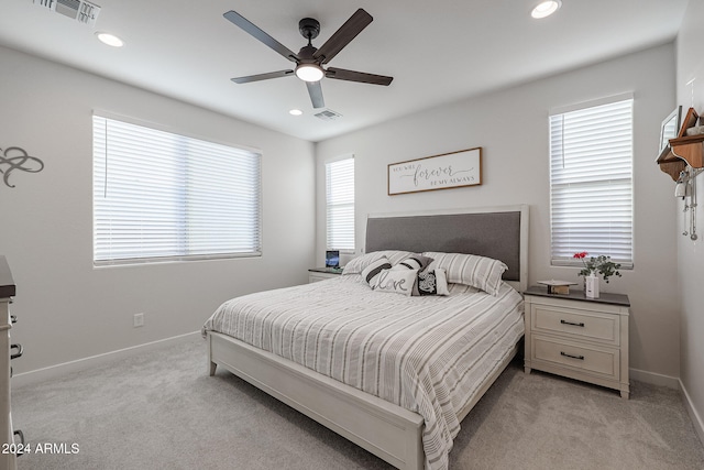 carpeted bedroom featuring ceiling fan and multiple windows