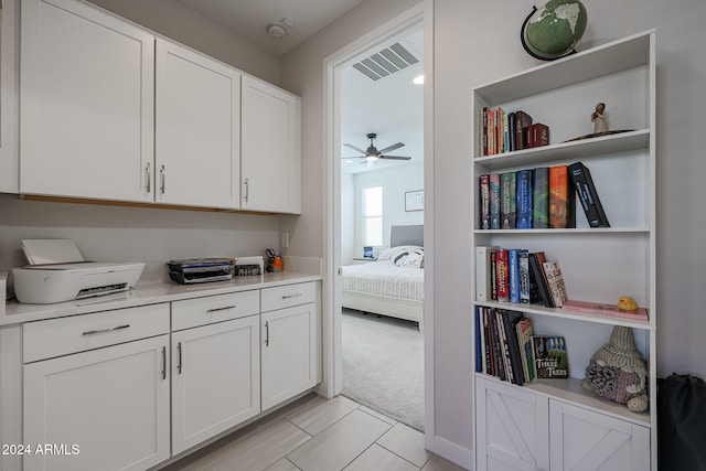 interior space with light carpet and ceiling fan