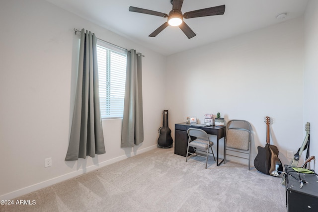 carpeted home office featuring ceiling fan